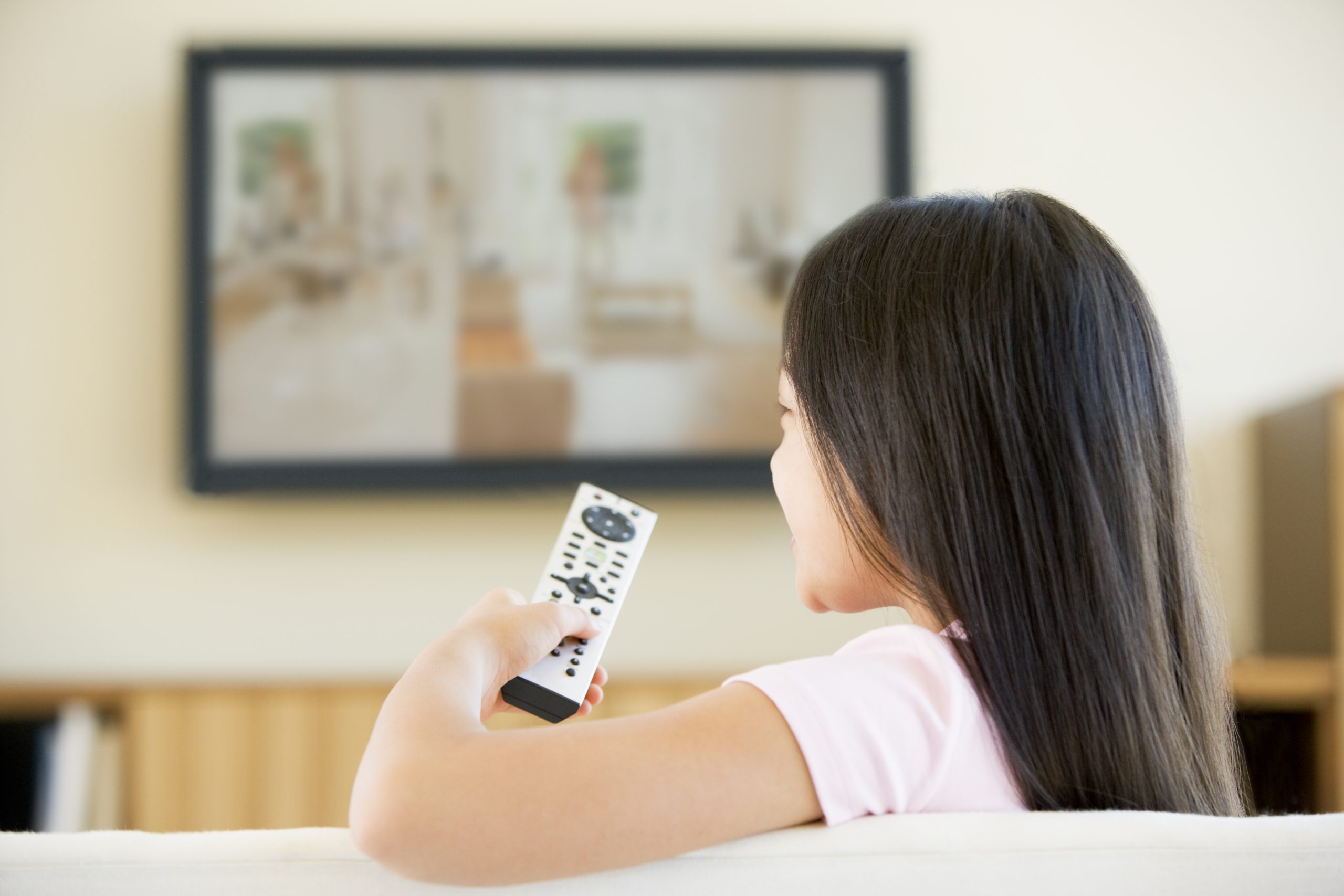 Young girl watching TV to learn English with TV series.